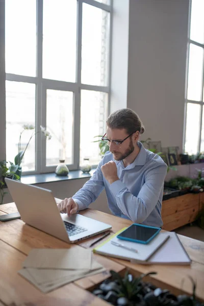 Uppmärksam man med glasögon tittar på laptop. — Stockfoto