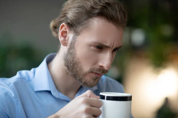 Giovane uomo serio con sguardo intelligente con tazza in mano . — Foto Stock