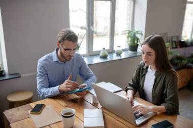 Kız ve erkek ofiste aletlerle çalışıyor..