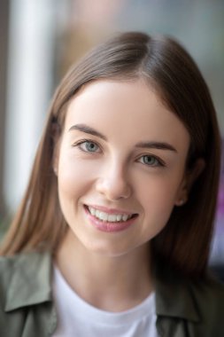 Neşeli ve kendine güveni tam genç bir kadın.