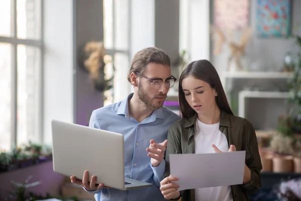 Man met een laptop en meisje met regeling in functie. — Stockfoto