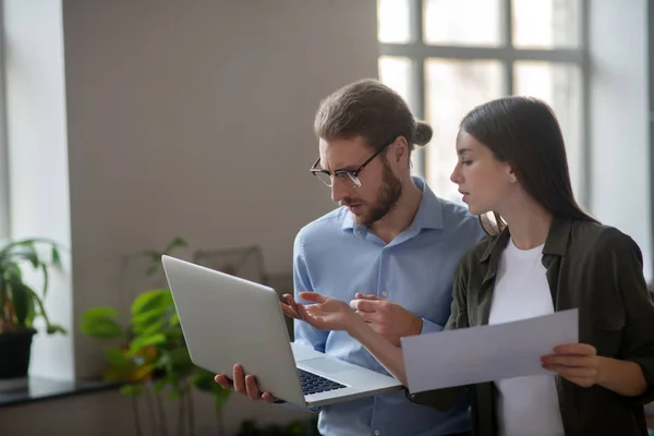 Flicka och man med bärbar dator diskuterar arbetsplan. — Stockfoto