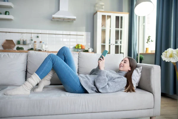 Junges Mädchen im grauen Pullover verbringt ihren Tag zu Hause — Stockfoto