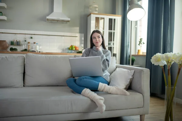 Chica joven en un suéter gris trabajando remotamente — Foto de Stock