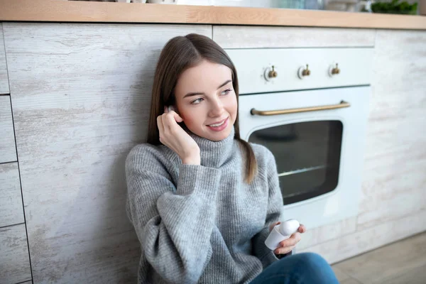 Chica de pelo oscuro en un suéter gris escuchando música — Foto de Stock