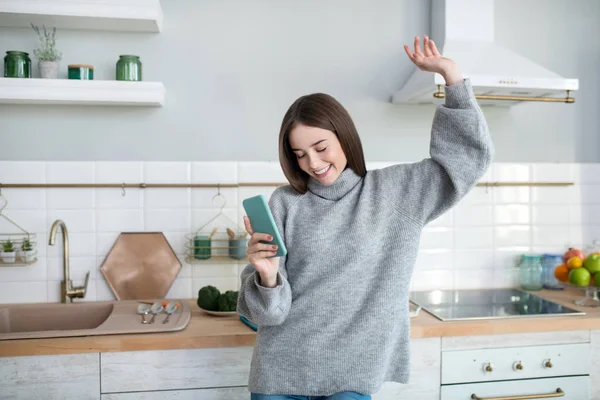 Dark-haired girl in a grey sweater feeling great — Stockfoto