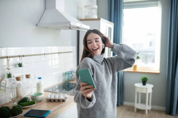 Chica de pelo oscuro en un suéter gris sonriendo y haciendo selfie — Foto de Stock