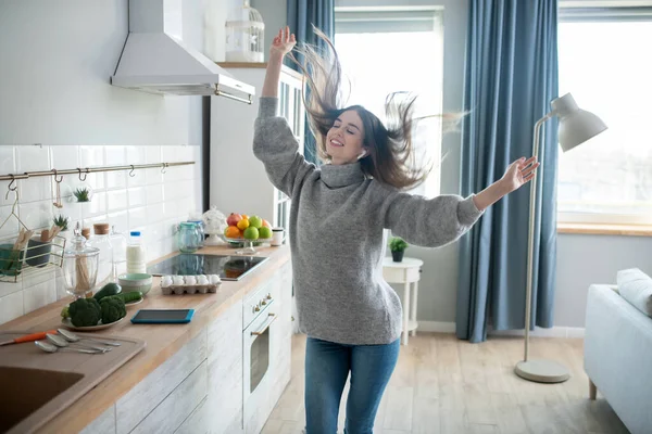 Chica morena en un suéter gris divirtiéndose en casa — Foto de Stock