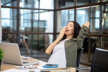 Long-haired brunette asian girl feeling tired and yawning