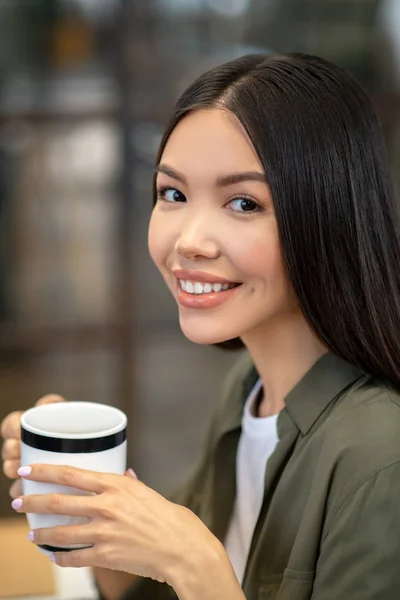 Lang haar brunette aziatisch meisje zitten en het hebben van koffie — Stockfoto