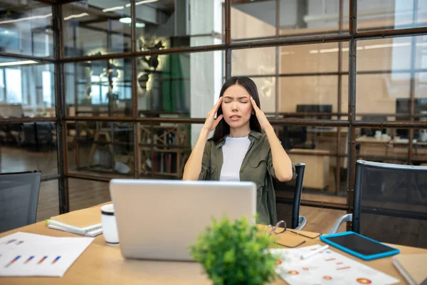 Long-haired brunette asian girl suffering from headache — Stockfoto