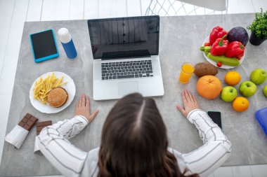 Dark-haired woman in a striped blouse working at home