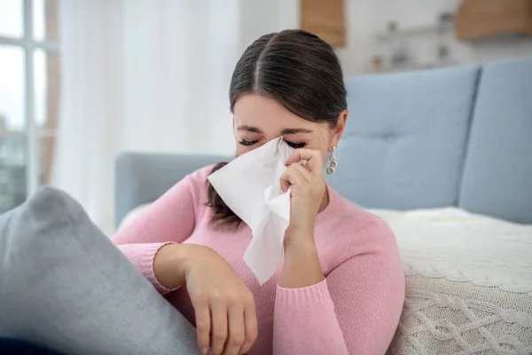 Közelről egy fiatal nő rózsaszín ingben sír — Stock Fotó