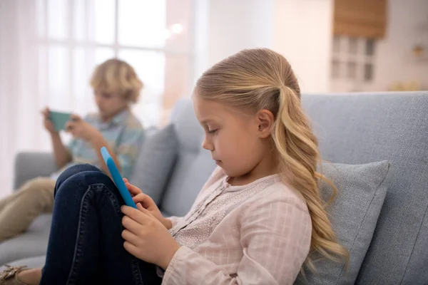 Barn som sitter på soffa med prylar, leker lekar — Stockfoto