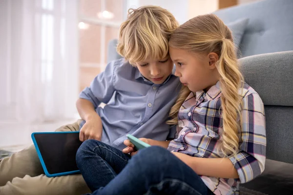 Niño y niña viendo algo en la tableta y discutiendo — Foto de Stock