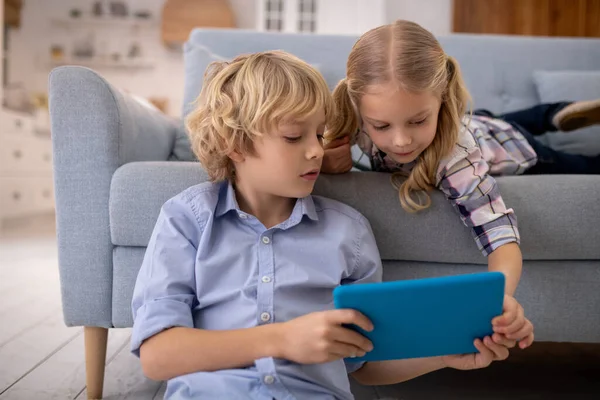 Jongen en meisje kijken iets op tablet — Stockfoto