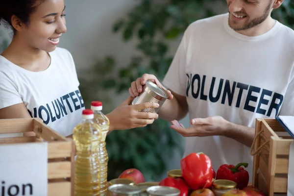 Jovencita, hombre empacando comida gratis para los necesitados . — Foto de Stock