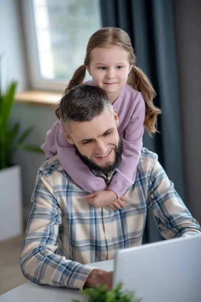 Alegre papá joven, hija pequeña sonriendo mirando un ordenador portátil . — Foto de Stock