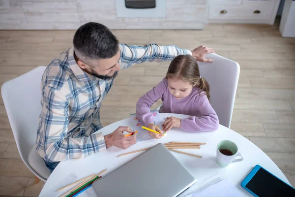 Father with daughter painting at table in kitchen. — Stockfoto