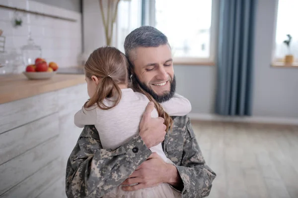 Smiling dad in uniform hugging tightly daughter. — 스톡 사진
