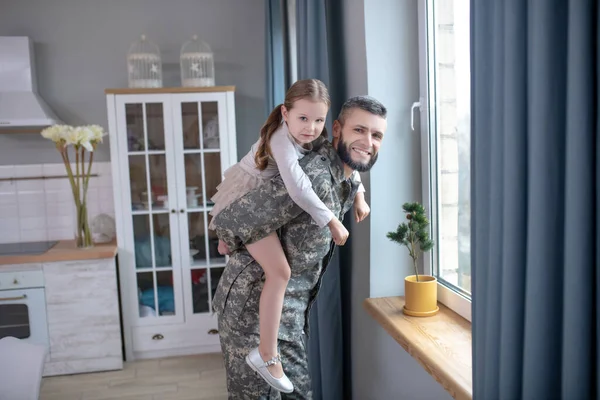 Dad in camouflage holding a little daughter on his back. — 스톡 사진