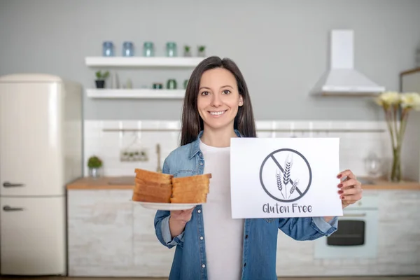 Γυναίκα κρατώντας ένα πιάτο με ψωμί και κανένα σημάδι γλουτένης — Φωτογραφία Αρχείου