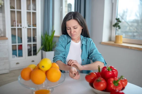 Woman itching her hand after eating allergens — Stockfoto