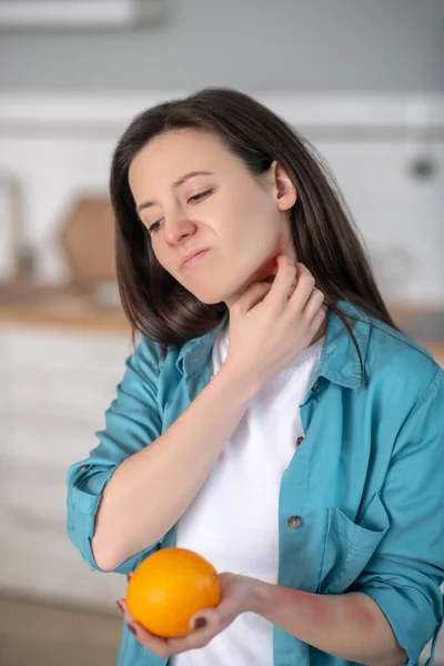 Woman having symptomes of being allergic to oranges — Stok fotoğraf