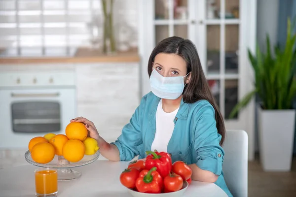 Mujer con máscara médica en su cocina — Foto de Stock