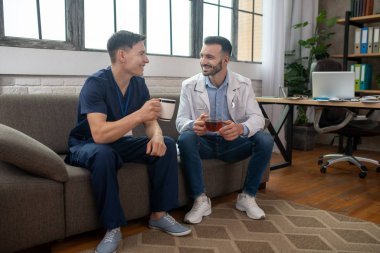 Two young doctors having conversation during breakfast