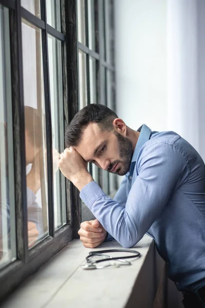 Young bearded man standing near the window in thoughts — 스톡 사진