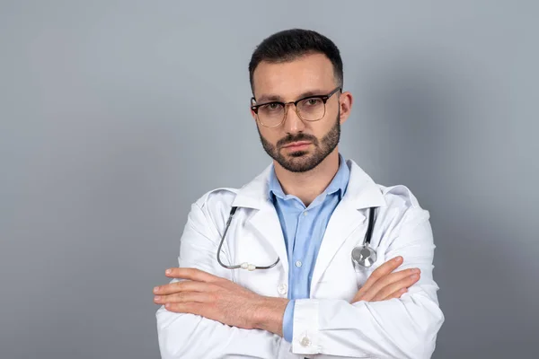 Doctor in eyeglasses standing with arms crossed — ストック写真