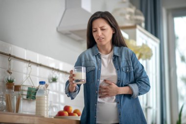 Woman having a stomach ache after drinking milk