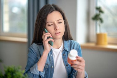 Woman talking on phone to her doctor about new pills clipart