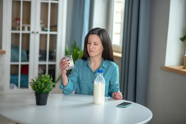 Mujer que bebe leche a pesar de no gustarle los productos lácteos — Foto de Stock