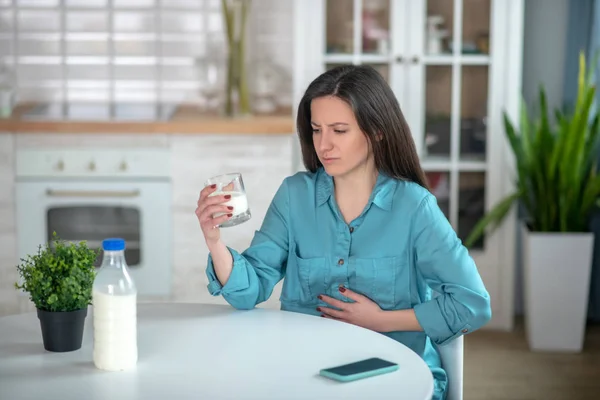 Femme qui boit du lait parce qu'elle a mal au ventre — Photo