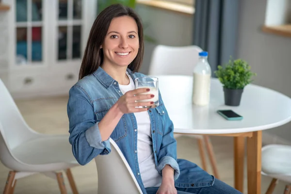 Sorrindo mulher bebendo leite na cozinha — Fotografia de Stock