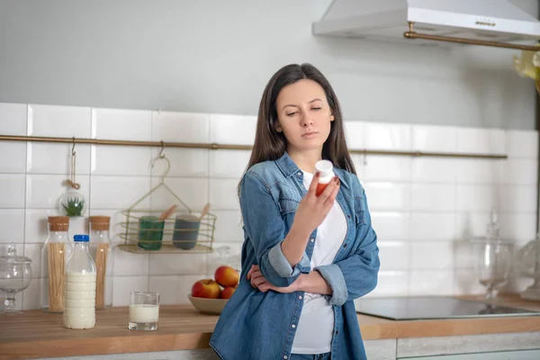 Mujer leyendo información sobre el envase para pastillas — Foto de Stock