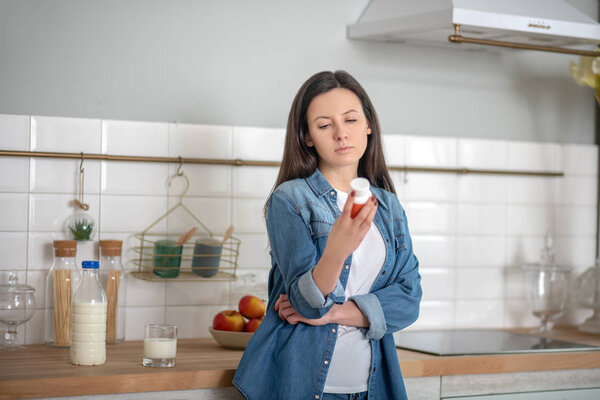 Женщина читает информацию о контейнере для таблеток
