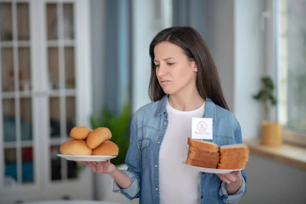 Woman holding plates with gluten free bread — Stock Photo, Image