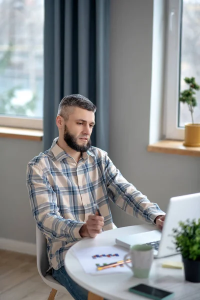 Young man sitting at the table distracted from work. — Stockfoto