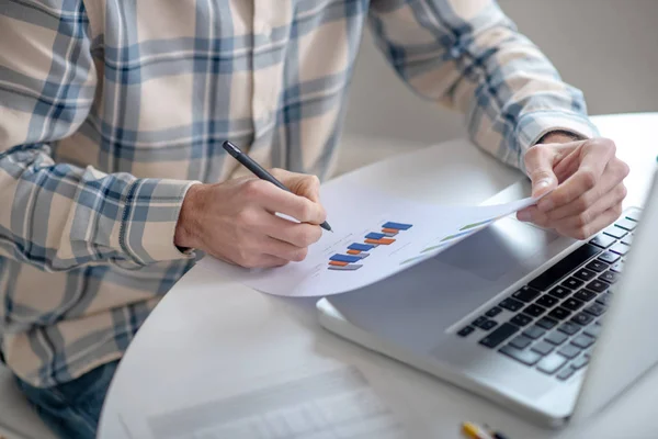 Männerhände mit einem Blatt Papier und einem Stift. — Stockfoto