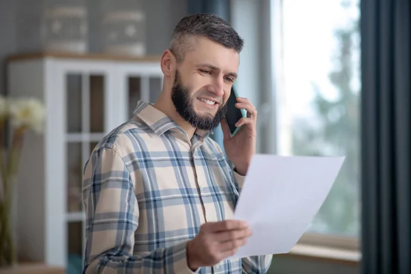 Young smiling man talking on a smartphone at home. — 스톡 사진