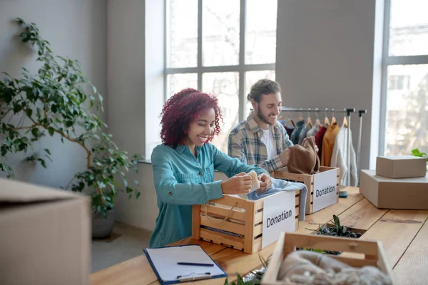 Joven adulto hombre y chica clasificación de ropa . — Foto de Stock