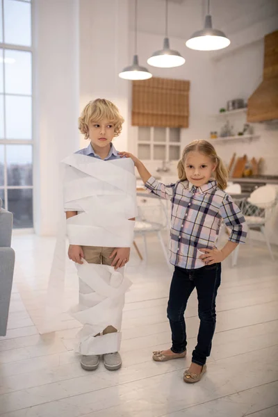 Twee kinderen spelen wc-papier mummie spel thuis — Stockfoto