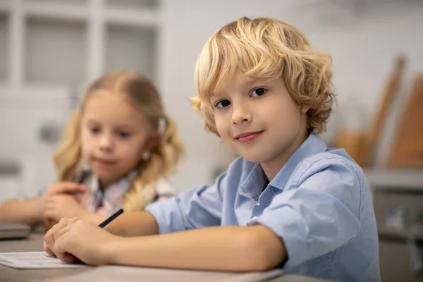 Dos niños sentados en la mesa y guapos — Foto de Stock