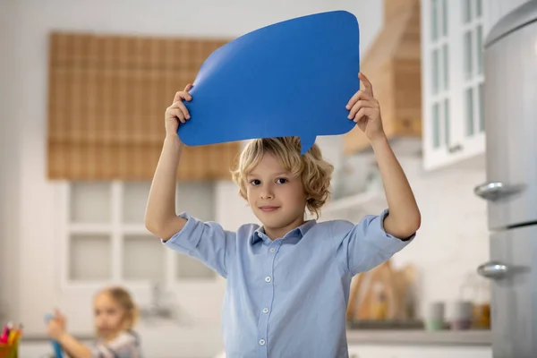 Blond kind in een blauw shirt voelt zich goed — Stockfoto