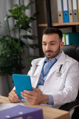 Beyaz cüppeli genç sakallı doktor ilgilendi.