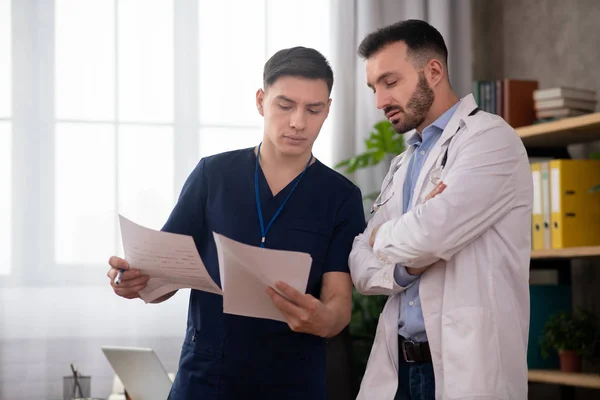 Zwei junge Ärztinnen diskutieren während der Umstellung im Personalraum über medizinische Fälle — Stockfoto