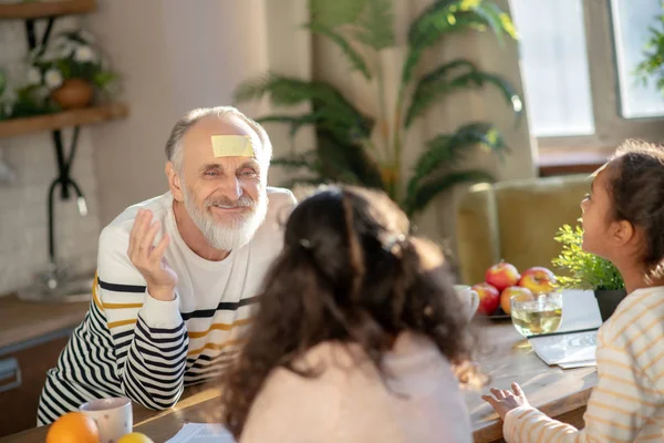 Homem de cabelos grisalhos tendo grande momento suas netas — Fotografia de Stock